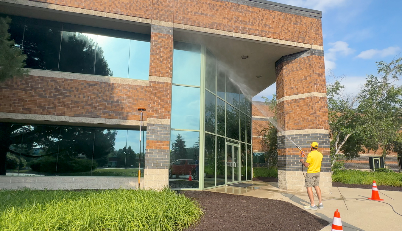 Technician restoring streak-free windows on a commercial building