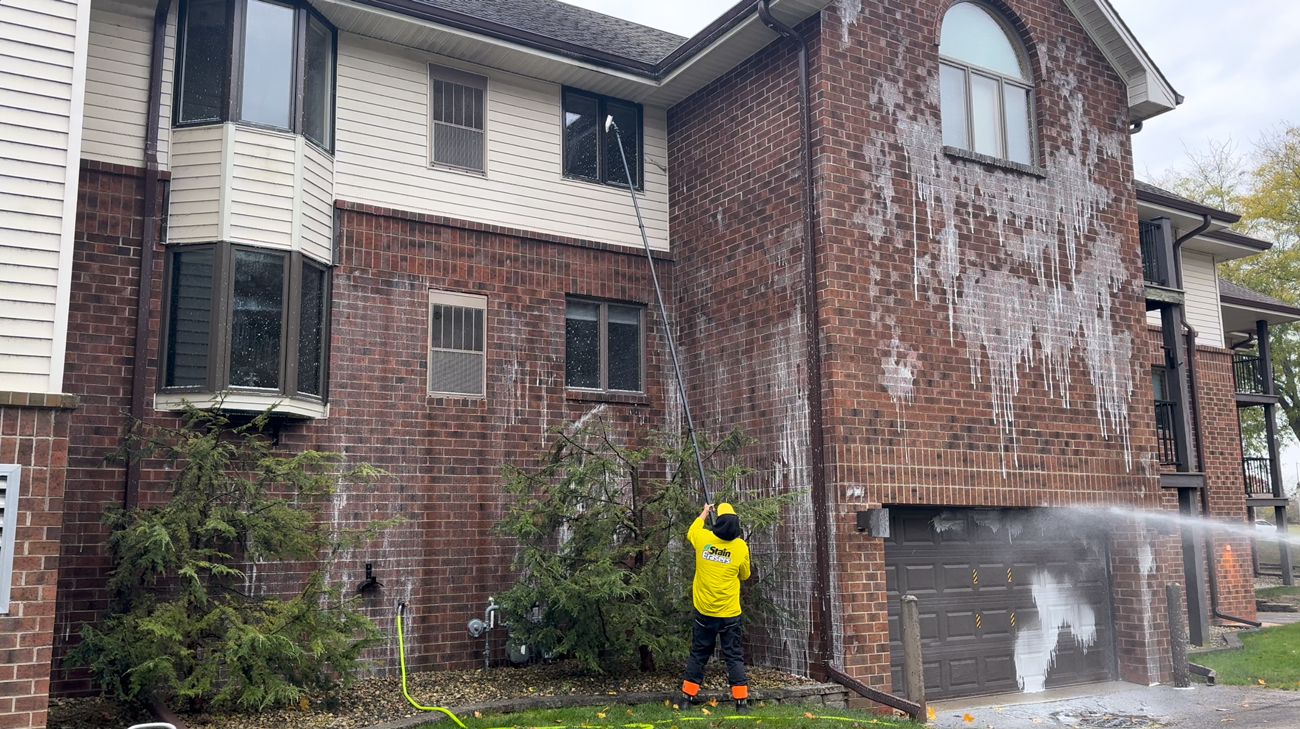 Technician treating the windows and exterior surfaces of a commercial building